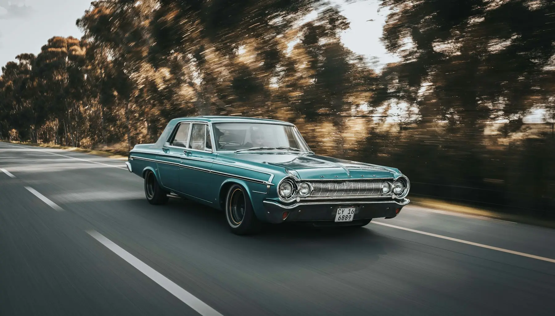 Tirkizni oldtimer u vožnji kroz šumu